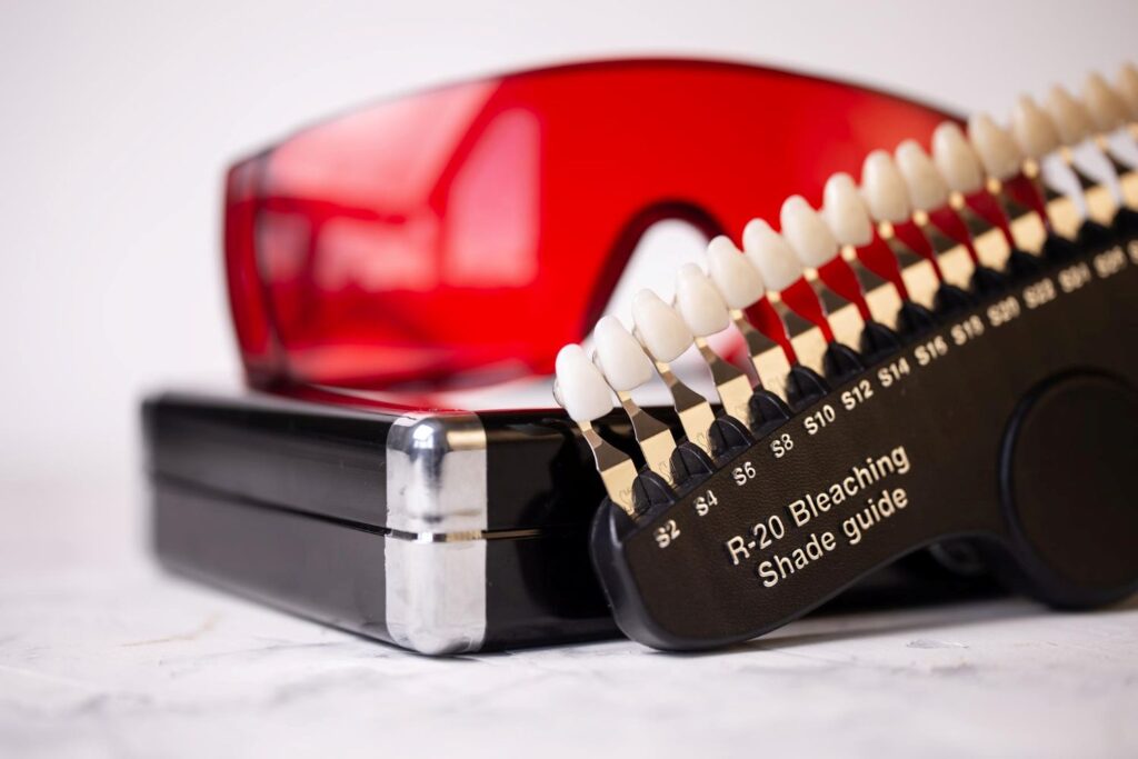 Gama bieli licówek przedstawiona na tle sprzętu stomatologicznego