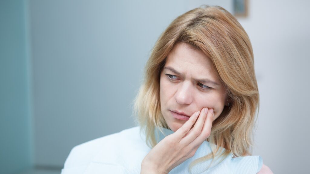 Na zdjęciu nadwrażliwość zębów u kobiety.
