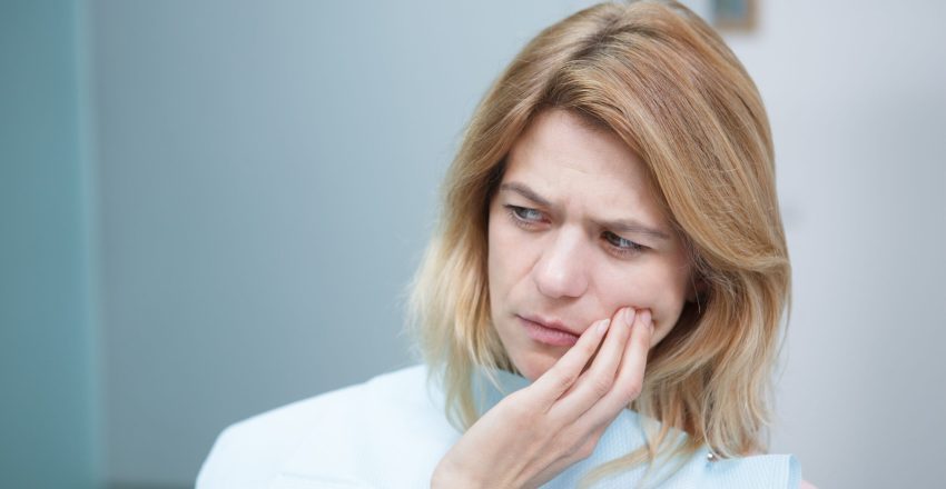 Na zdjęciu nadwrażliwość zębów u kobiety.